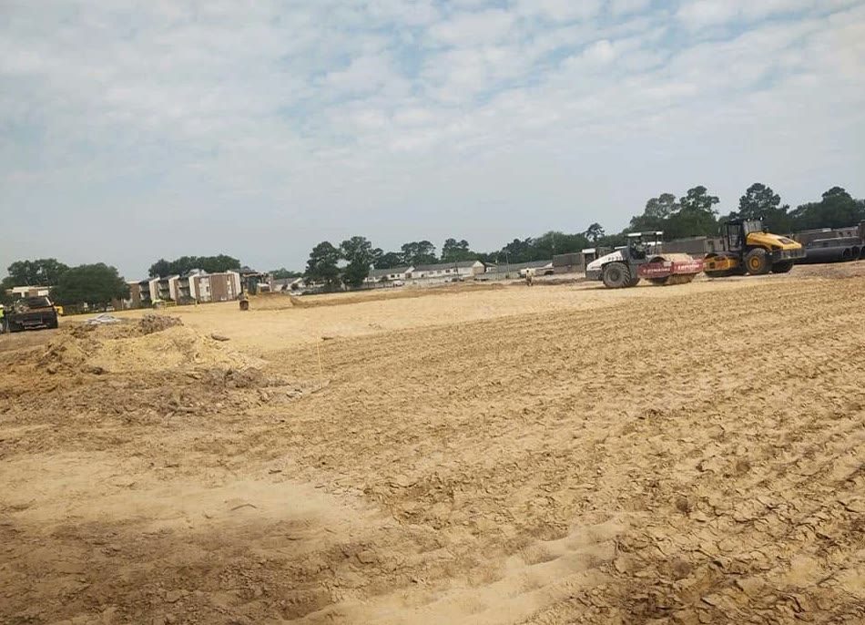 Rollers compacting a large commercial building pad