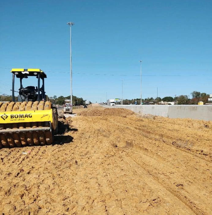 Padfoot roller compacting a road bed along a highway