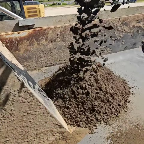 Cement stabilized sand pouring from the plant conveyor